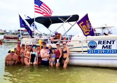 A family in front of a pontoon boat rental in Orange Beach Alabama